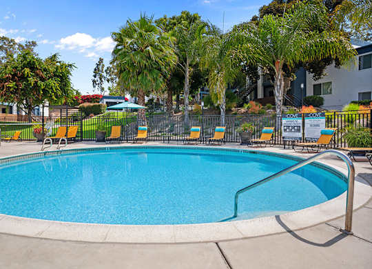 Community Swimming Pool with Pool Furniture at Cove La Mesa Apartments located in La Mesa, CA.