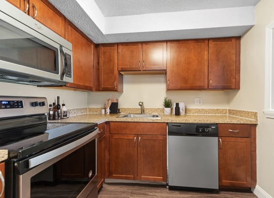 Model Kitchen with Brown Cabinets and Tile at Meadows at Marlborough Apartments in Boston, MA.