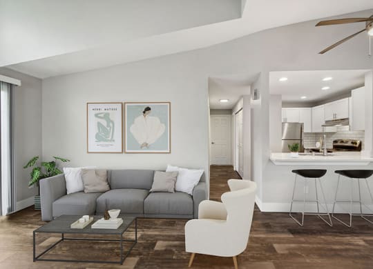 Model Living Room with Wood-Style Flooring, Patio Accessibility and View of Kitchen at Central Flats Apartments in Kent, WA.