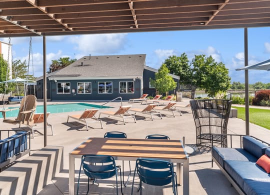 Community Swimming Pool with Pool Furniture at Waterfront Apartments in Lakewood, CO.