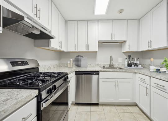 Model Kitchen with White Cabinets and Tile Flooring at Middlesex Crossing Apartments in Billerica, MA.