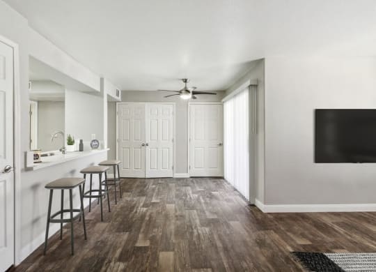 Model living area with a ceiling fan and three stools