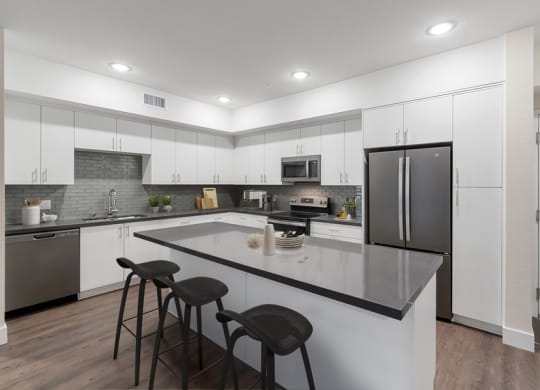 Model kitchen with white cabinetry and bar