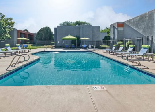 Community Swimming Pool with Pool Furniture at Indigo Park Apartments in Albuquerque, NM.