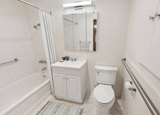 Model Bathroom with White Cabinets, Tile Flooring & Shower/Tub at Walnut Creek Apartments located in Walnut Creek, CA.