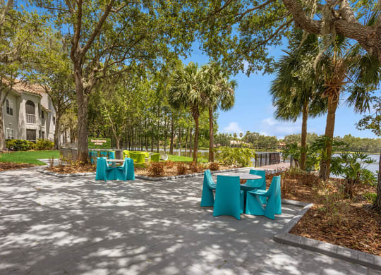 Patio with blue tables and chairs with the lake in the background