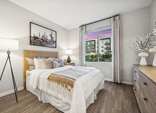 Model Bedroom with Wood-Style Flooring and Window View at Glen 91 Apartments located in Glendale, AZ.