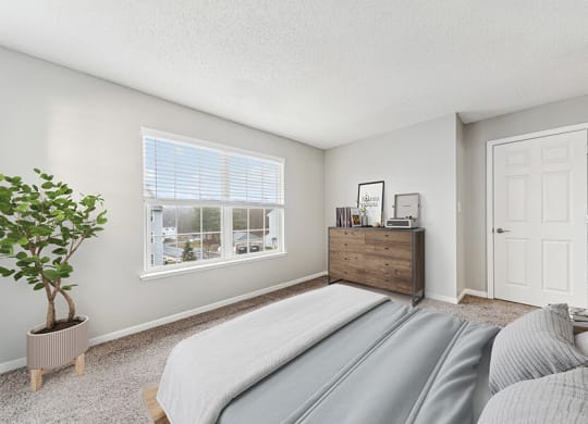 Model Bedroom with Carpet and Window View at Commons at Haynes Farm Apartments in Shrewsbury, MA.