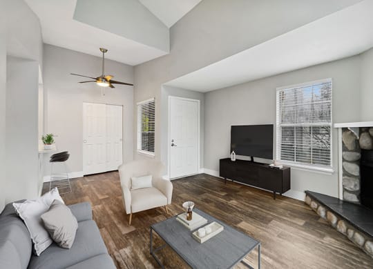 Model Living Room with Wood-Style Flooring, a Fireplace and Patio Accessibility at Central Flats Apartments in Kent, WA.