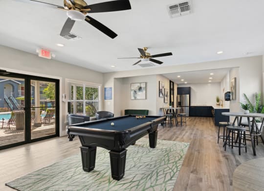Community lounge with billiards table at Retreat at Crosstown Apartments