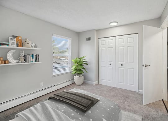 Model Bedroom with Carpet and Closet at Waterfront Apartments in Lakewood, CO.