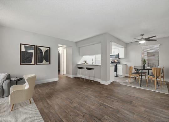 Model Dining Room and Kitchen Area with Wood-Style Flooring at Crystal Creek Apartments located in Phoenix, AZ.