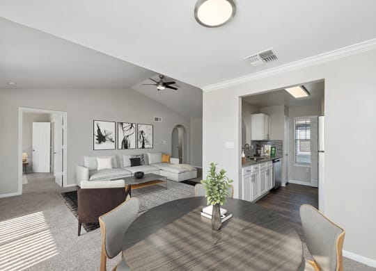 Model Dining Room with Carpet and View of Kitchen and Living Room at Hidden Creek Apartments in Lewisville, TX.
