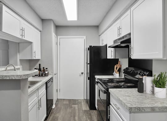 Model Kitchen with White Cabinets and Wood-Style Flooring at Abbington Heights Apartments in Antioch, TN.