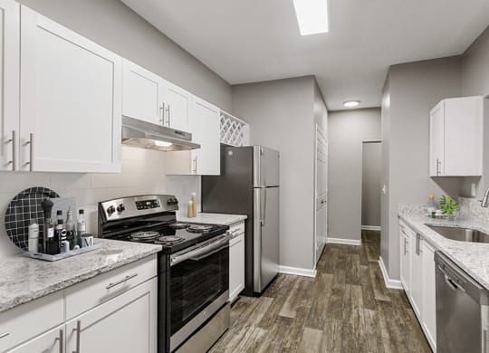 Model Kitchen with White Cabinets and Wood-Style Flooring at Parkside at Town Center Apartments in Marietta, GA.
