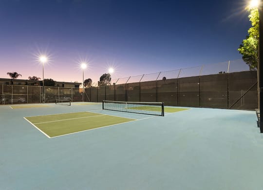 Community Tennis Court with Nets at Madison Park Apartments located in Anaheim, CA.