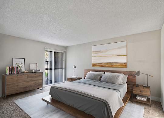 Model Bedroom with Carpet and Patio Accessibility at Madison Park Apartments located in Anaheim, CA.