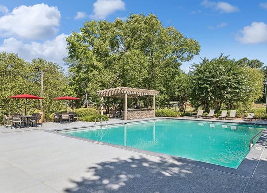 Community Swimming Pool with Pool Furniture at Lakeside Retreat Apartments located in Peachtree Corners, GA.