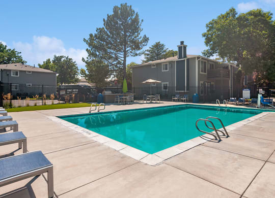 Community Swimming Pool with Pool Furniture at Overlook Apartments located in Salt Lake City, UT.