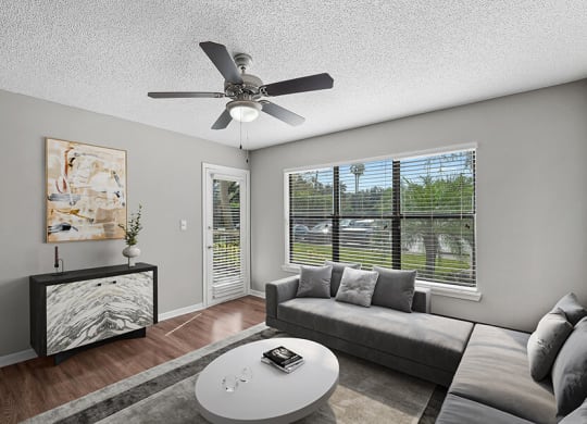 Model Living Room with Wood-Style Flooring and Patio Accessibility at Fountains Lee Vista Apartments in Orlando, FL.