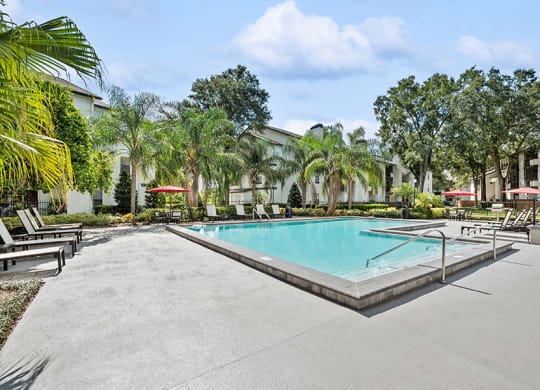 Community Swimming Pool with Pool Furniture at Rosehill Preserve Apartments in Orlando, FL.