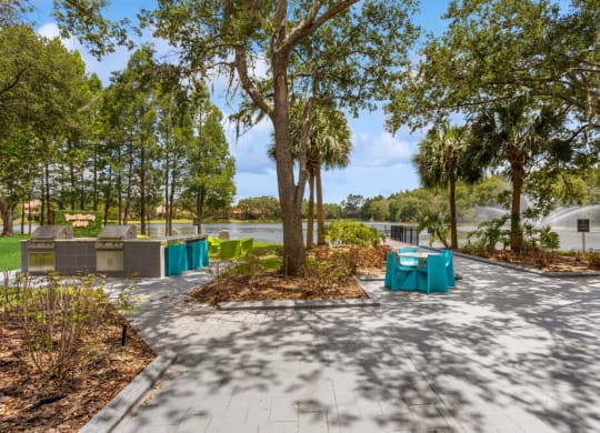Pathway with tables and chairs on it with the lake  in the background