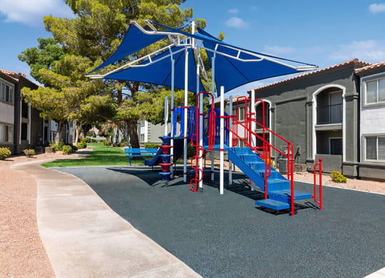 Community Playground with a Slide and Blue Canopy at Loma Vista Apartments in Las Vegas, NV.