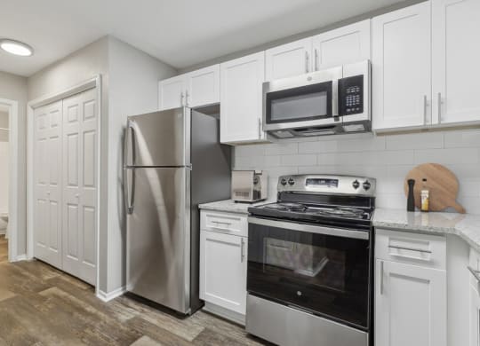 a kitchen with stainless steel appliances and white cabinets