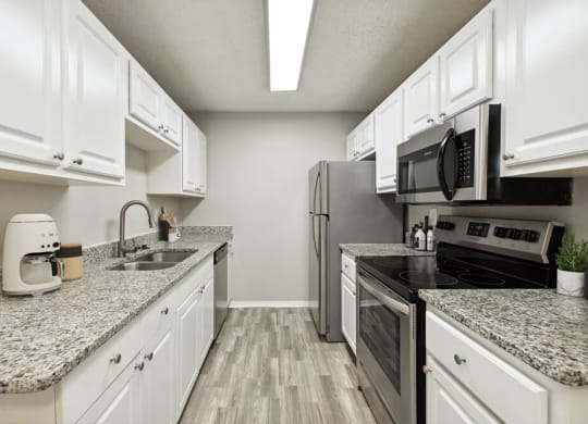 Model kitchen with granite countertops and white cabinets