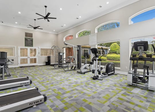 a workout room with treadmills and other exercise equipment