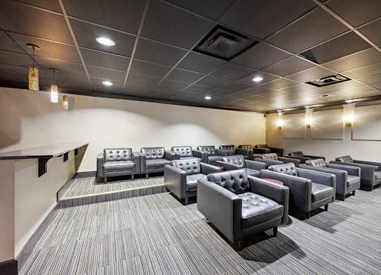 Community Theater Room with Seating at Dulles Green Apartments located in Herndon, VA.
