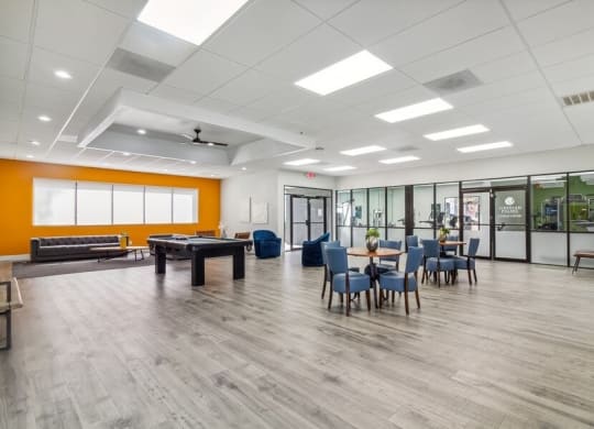 a large room with a pool table and chairs