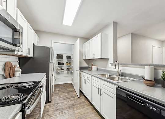 Model Kitchen with White Cabinets and Wood-Style Flooring at Lake Cameron Apartments located in Apex, NC.