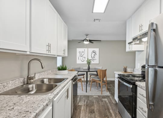 Model Kitchen with White Cabinets and Wood-Style Flooring at Peaks on 4th Apartments in Avondale, AZ.
