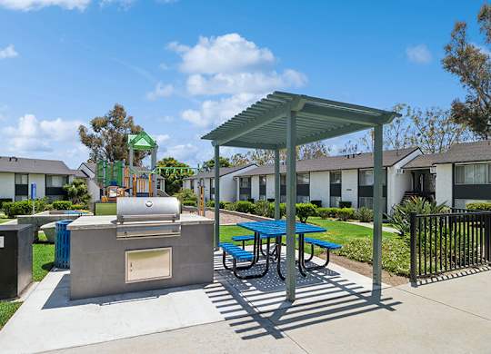 Outdoor BBQ Area with Canopy and Picnic Tables at Fullerton Hills Apartments located in Fullerton, CA.
