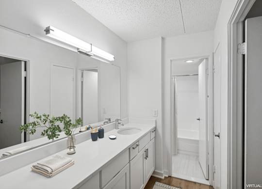 Model bathroom with a white counter top and a white sink.