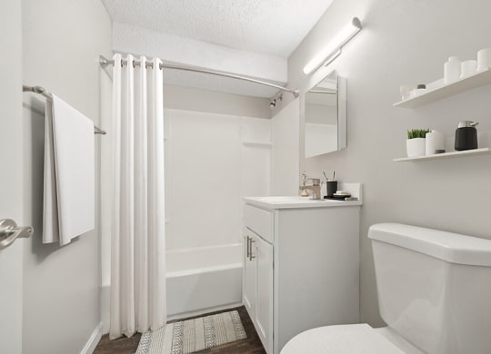Model Bathroom with White Cabinets, Wood-Style Flooring and Shower/Tub at Meadows at Marlborough Apartments located in Marlborough, MA.
