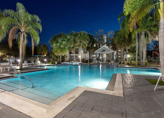 Community Swimming Pool with Pool Furniture at Caribbean Breeze Apartments in Tampa, FL.