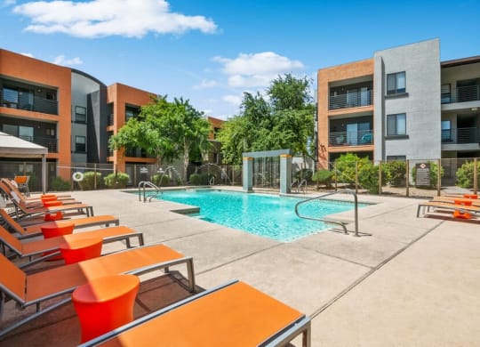 Community Swimming Pool with Pool Furniture at Harmony at Surprise Apartments in Surprise, AZ.