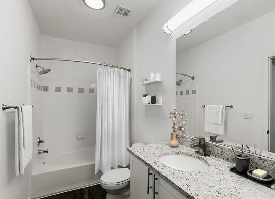 Model Bathroom with White Cabinets, Wood-Style Flooring and Shower/Tub at Parkside at Town Center Apartments in Marietta, GA.