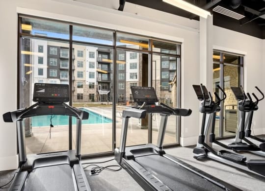 treadmills with view of pool in gym
