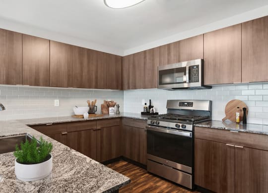 Model Kitchen with Wood-Style Flooring & Dark Oak Cabinets at Seven Skies Apartments located in Sandy, UT.