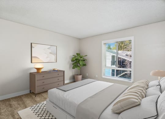 Model bedroom with a large bed next to a window