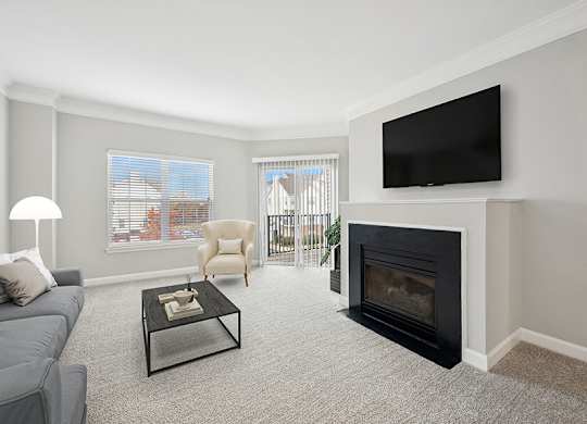 Model Living Room with Carpet and Fireplace at Dulles Green Apartments located in Herndon, VA.