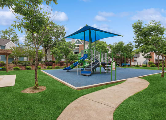 Community Playground with a Slide, Blue Canopy and Swing Set at Park 2300 Apartments in Charlotte, NC.
