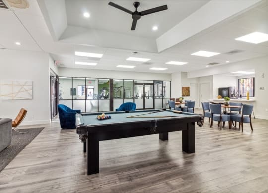 a pool table in a room with a couch and chairs