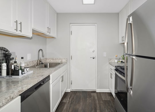 Model Kitchen with White Cabinets and Wood-Style Flooring at Stone Ends Apartments in Stoughton, MA.