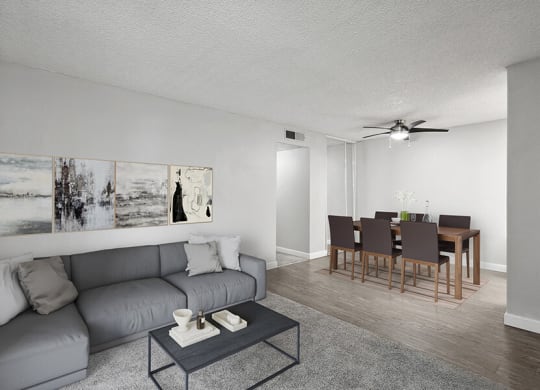 Model Living Room with Carpet and View of Dining Room with Wood-Style Flooring at The Archer Apartments in Sacramento, CA.