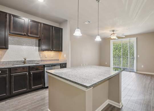 Model kitchen with dark brown cabinets and a granite countertop.