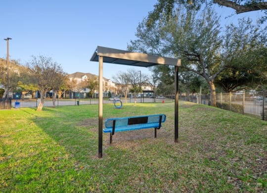 Fenced-in dog park with agility equipment at Park West Apartments in Houston, Texas
